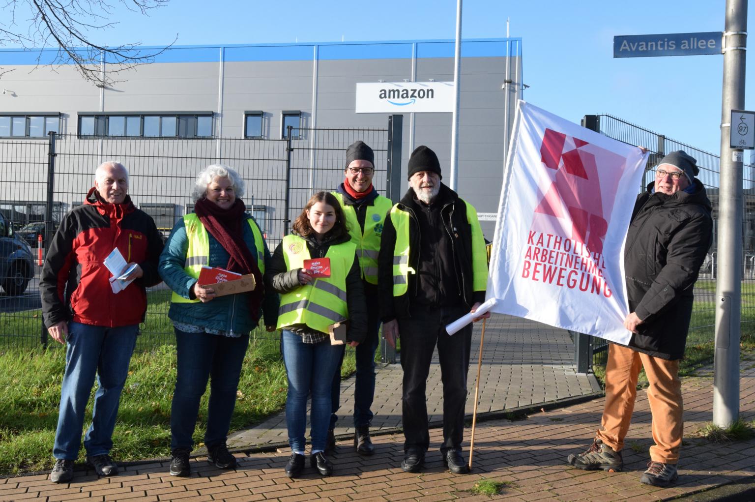Vereinte Solidarität zum Black Friday 2022 vor dem Amazon-Verteilzentrum im Gewerbegebiet zwischen Aachen und Heerlen. Von links nach rechts: Heinz Backes, Ursula Rohrer, Anna Schlecht, Dr. Manfred Körber, Andris Gulbins und Hans-Werner Quasten. (c) Thomas Hohenschue