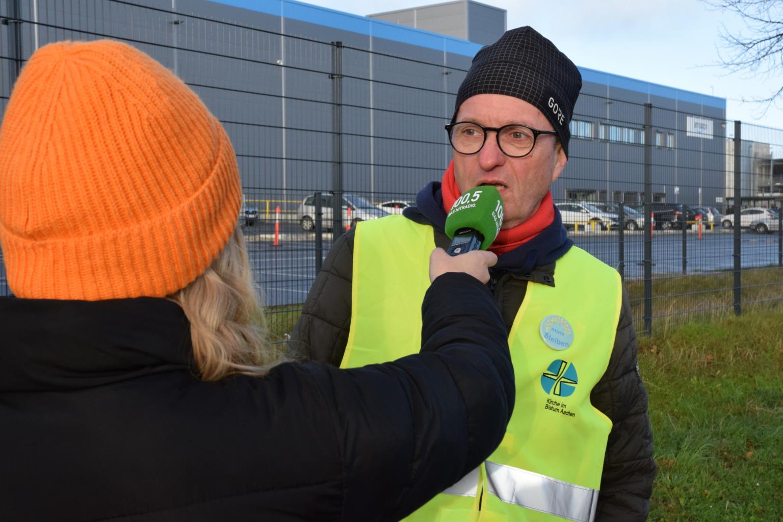 Mit der Aktion wollte das Bündnis auch ein öffentliches Zeichen setzen, dass die Freude am vermeintlich günstigen Konsum auf die Knochen von Beschäftigten geht. Es gelang, eine Reihe von regionalen Medien für das Thema zu interessieren. Unser Bild zeigt Dr. Manfred Körber im Interview mit dem Lokalradio 100,5. (c) Thomas Hohenschue
